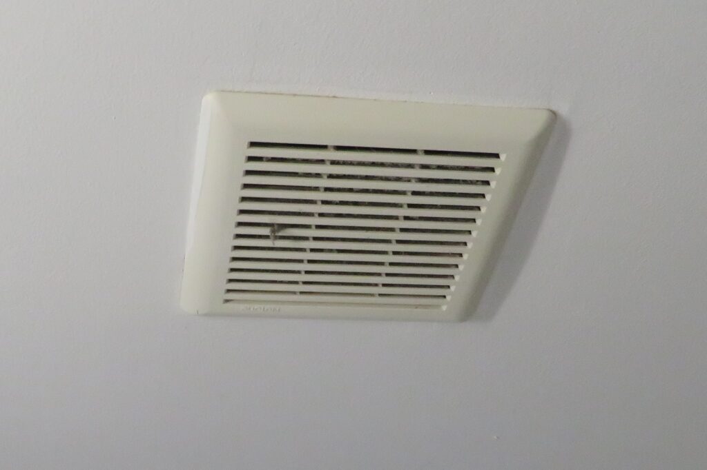 Bathroom exhaust fan grille with visible dust accumulation
